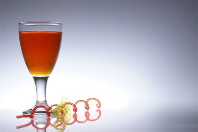 Close-up of cocktail in glass on table against wall