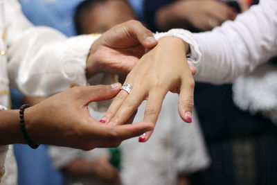 Midsection of couple holding hands