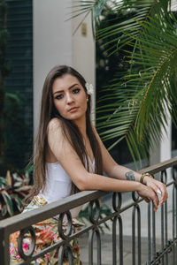 Portrait of woman sitting on railing