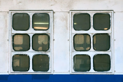 Two cabin windows and portholes on outboard side of ship. hull vintage ocean liner. old ship windows