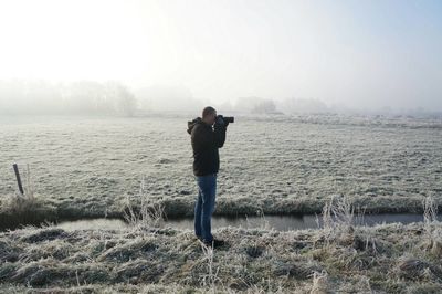 Full length of man standing on shore against sky