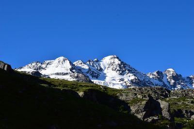 Scenic view of snowcapped mountains against clear blue sky