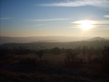 Scenic view of field against sky at sunset