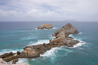 Scenic view of rock formation in sea against sky