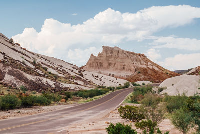 Road leading towards mountains against sky