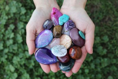 Cropped hands holding colorful pebbles