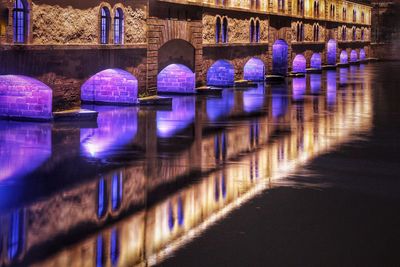 Illuminated bridge over river at night