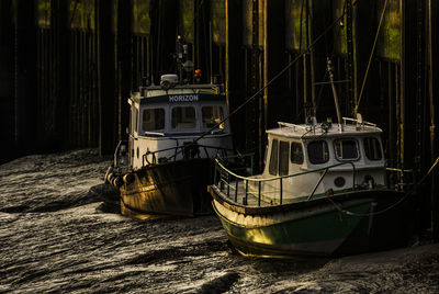 Boats moored on shore at night