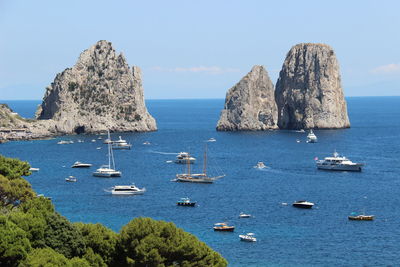 Boats moored in sea against clear sky