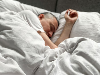 Middle aged man sleeping at home cozy bedroom bed vibes white alone early morning concept of comfort