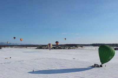 Hot air balloon flying over land against sky