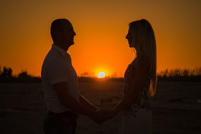 Silhouette of lovers against the backdrop of the setting sun