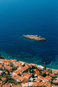 High angle view of townscape by sea against city