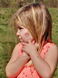 Close-up of cute girl lying on field