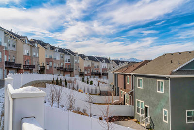 Houses in city against sky during winter