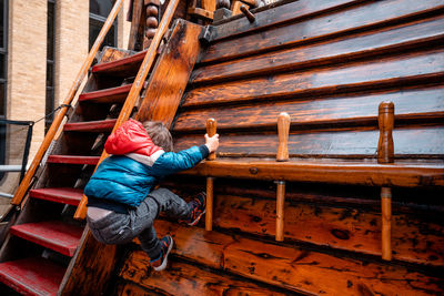 Full length of man sitting on ladder against boat