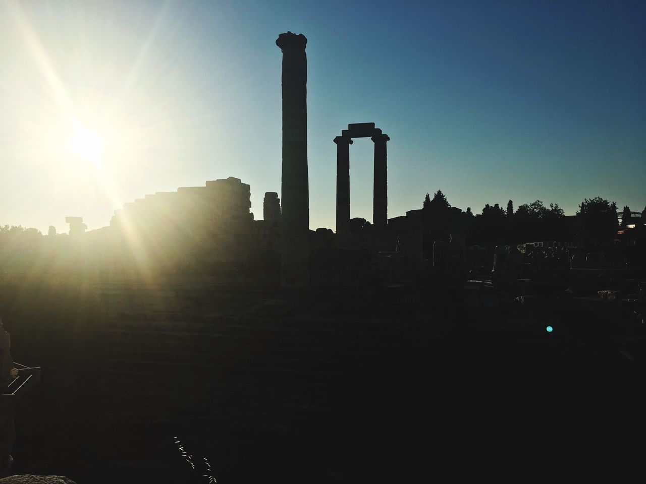 SUN SHINING OVER BUILDINGS DURING SUNSET