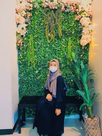 Full length of woman standing against plants