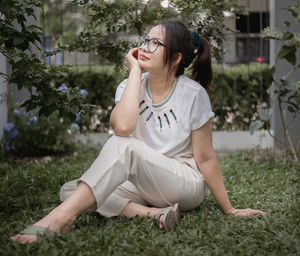 Full length of teenage girl sitting on field