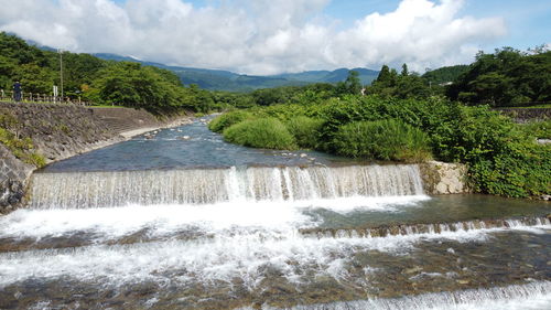 Scenic view of waterfall against sky