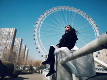 Statue of woman in city against clear blue sky