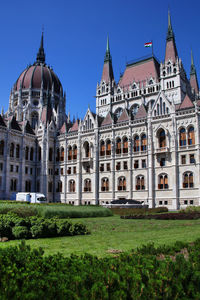 Building against clear sky with lawn in foreground