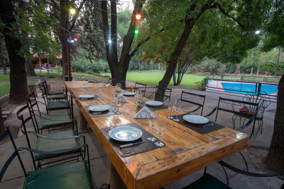 High angle view of empty chairs and table against trees