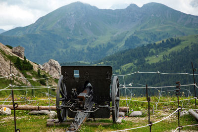 Men by fence on mountains against sky