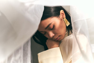 Portrait of young woman sleeping on bed