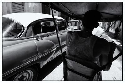 Rear view of man standing on car