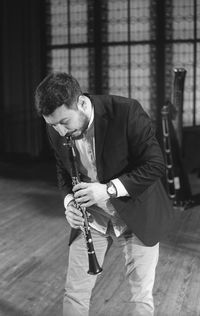 Man playing clarinet while standing at studio