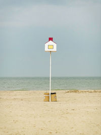 Lifeguard hut on beach against sky