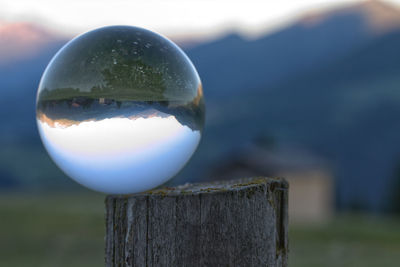 Close-up of crystal ball on wooden post