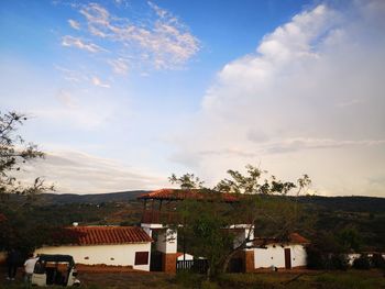 Houses and buildings in town against sky