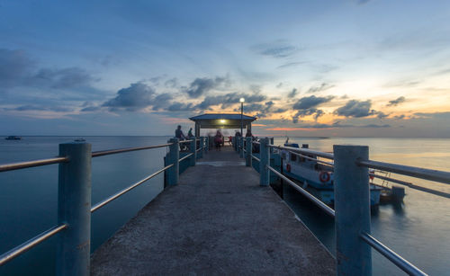 Pier over sea against sky during sunset