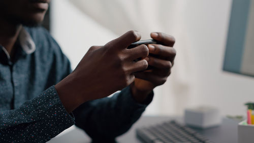 Midsection of man using mobile phone