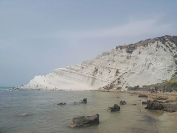 Scenic view of sea and mountains against sky