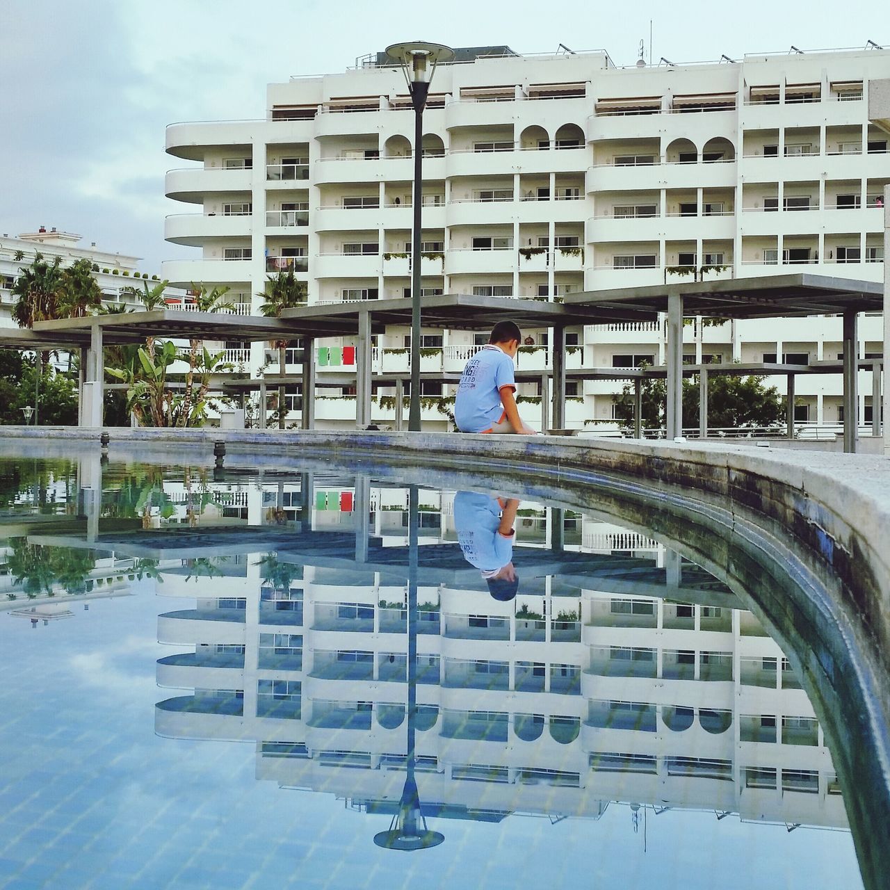 architecture, built structure, building exterior, full length, lifestyles, leisure activity, men, reflection, water, railing, city, sky, person, day, tree, rear view, outdoors, casual clothing