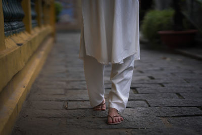 Low section of woman standing on footpath