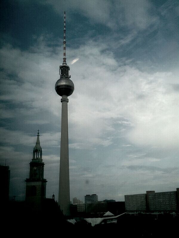 communications tower, tower, tall - high, architecture, building exterior, built structure, television tower, fernsehturm, spire, sky, international landmark, communication, capital cities, city, travel destinations, famous place, tourism, cloud - sky, travel, culture