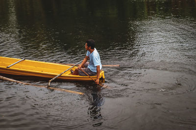 Rear view of man kayaking in lake