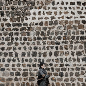 Young woman in front of stone wall