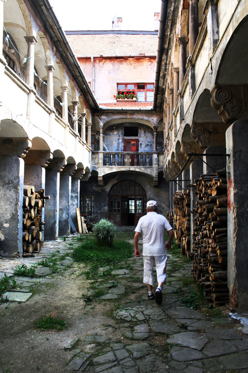 FULL LENGTH REAR VIEW OF MAN WALKING ON STREET