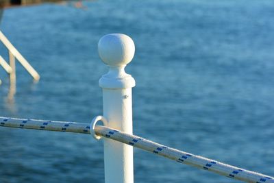 Close-up of metal railing against sea