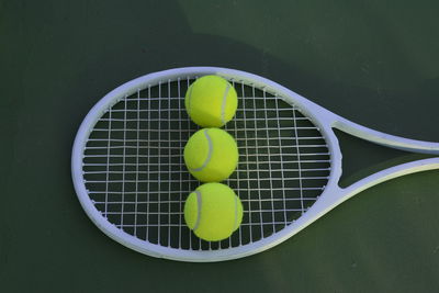 High angle view of balls and tennis racket at sports court