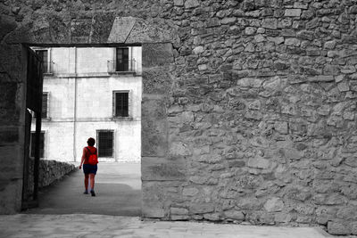 Full length rear view of man walking against building