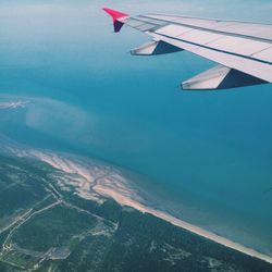 Cropped image of airplane flying over sea