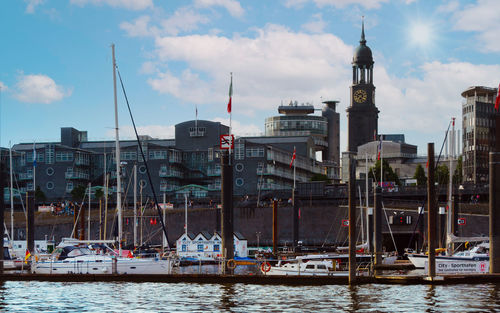 Sailboats in sea against buildings in city