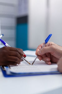 Close-up of woman hand holding paper on table