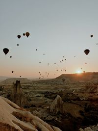 Hot air balloons flying against sky during sunset